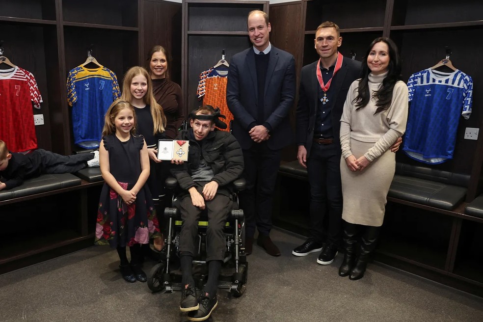 O Príncipe William se encontra com o treinador de rugby Kevin Sinfield (2º à direita) e o ex-jogador de rugby Rob Burrow (à frente) para parabenizá-los por sua atuação na conscientização sobre a Esclerose Lateral Amiotrófica (ELA) e condecorá-los com a Ordem do Império Britânico (CBE) durante sua visita ao Estádio Headingley em 11 de janeiro de 2024 — Foto: Getty Images