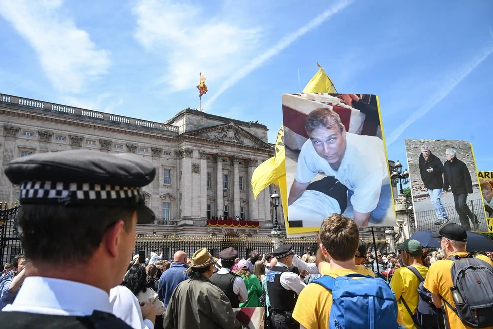 Um manifestante segura uma foto do ex-príncipe Andrew em frente ao Palácio de Buckingham após o desfile Trooping the Colour do rei Charles em Londres, em 13 de junho de 2026 — Foto: GettyImages