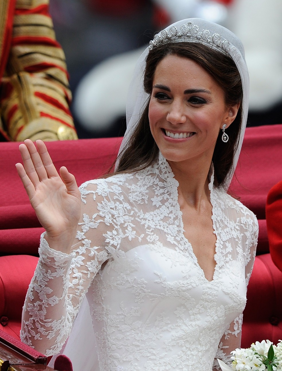 Para comportar a coroa da realeza britânica emprestada pela avó do noivo – a Rainha Elizabeth –, o penteado de Kate Middleton trouxe uma franja baixa, com uma leve onda. Apesar do tecido do vestido nas costas, o cabeleireiro respeitou o estilo da noiva e deixou os cabelos soltos na parte traseira — Foto: Vogue