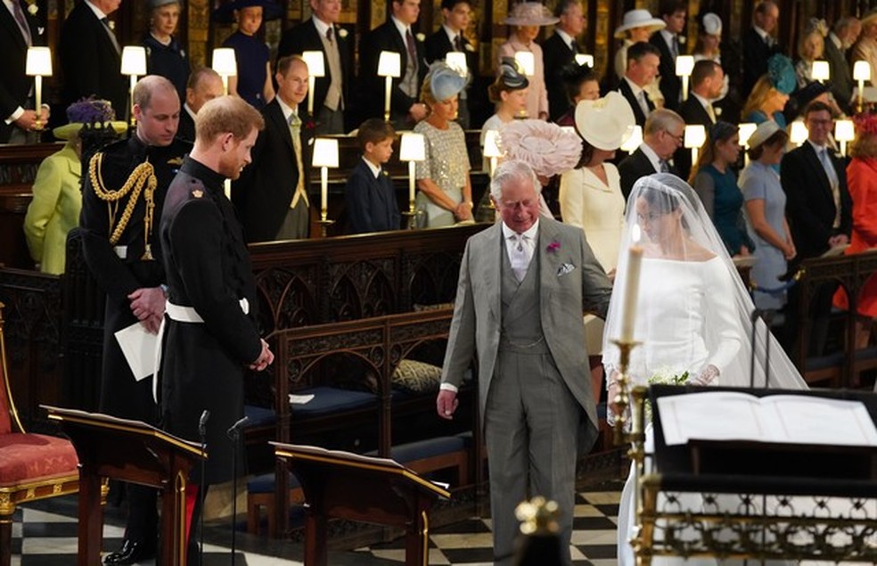 WINDSOR, UNITED KINGDOM - MAY 19:  Prince Harry looks at his bride, Meghan Markle, as she arrives accompanied by Prince Charles, Prince of Wales during their wedding in St George's Chapel at Windsor Castle on May 19, 2018 in Windsor, England. (Photo by Jo (Foto: Getty Images) — Foto: Vogue