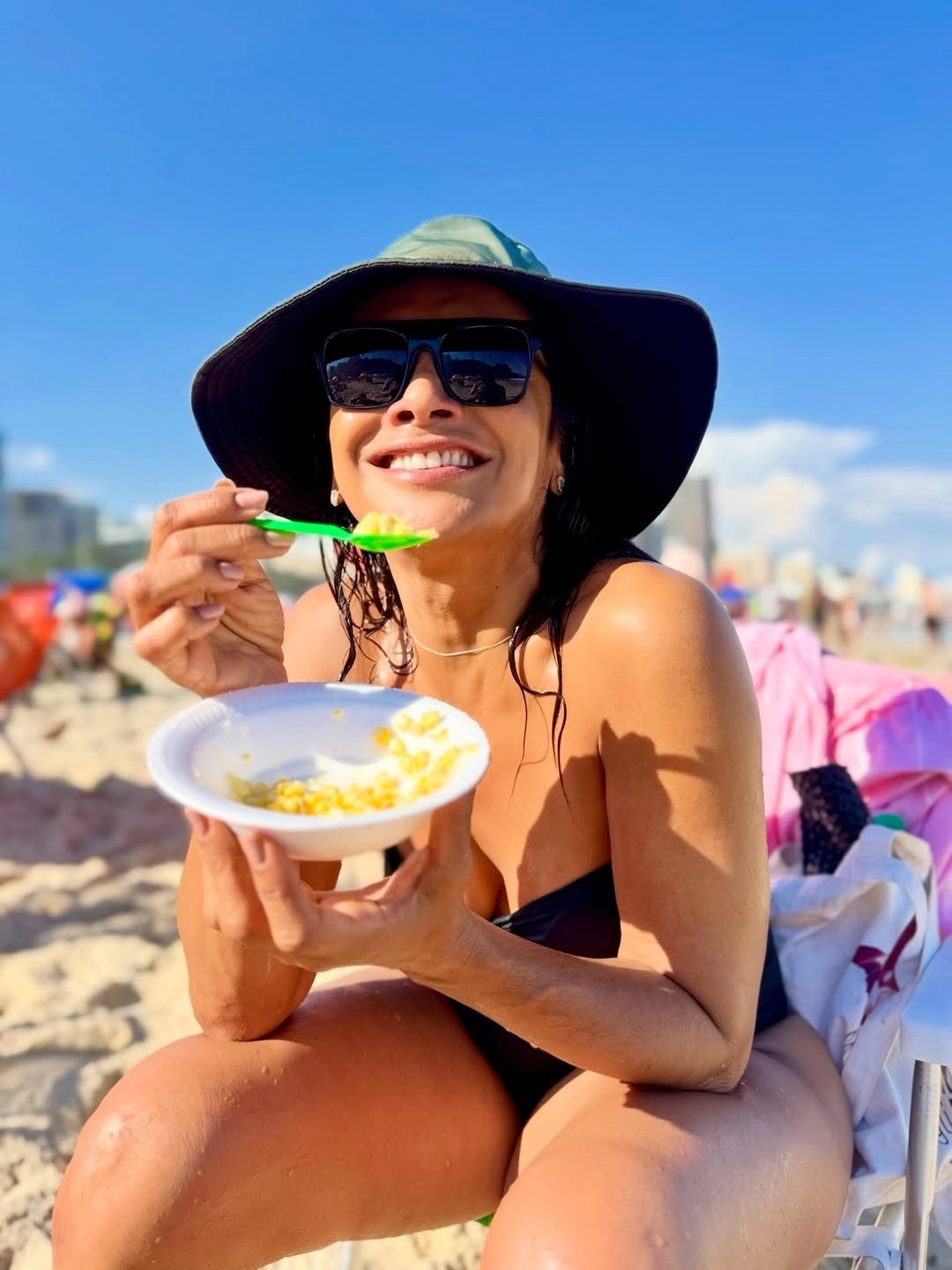 De biquíni e chapéu, Dira Paes aproveita milho na praia e Fa