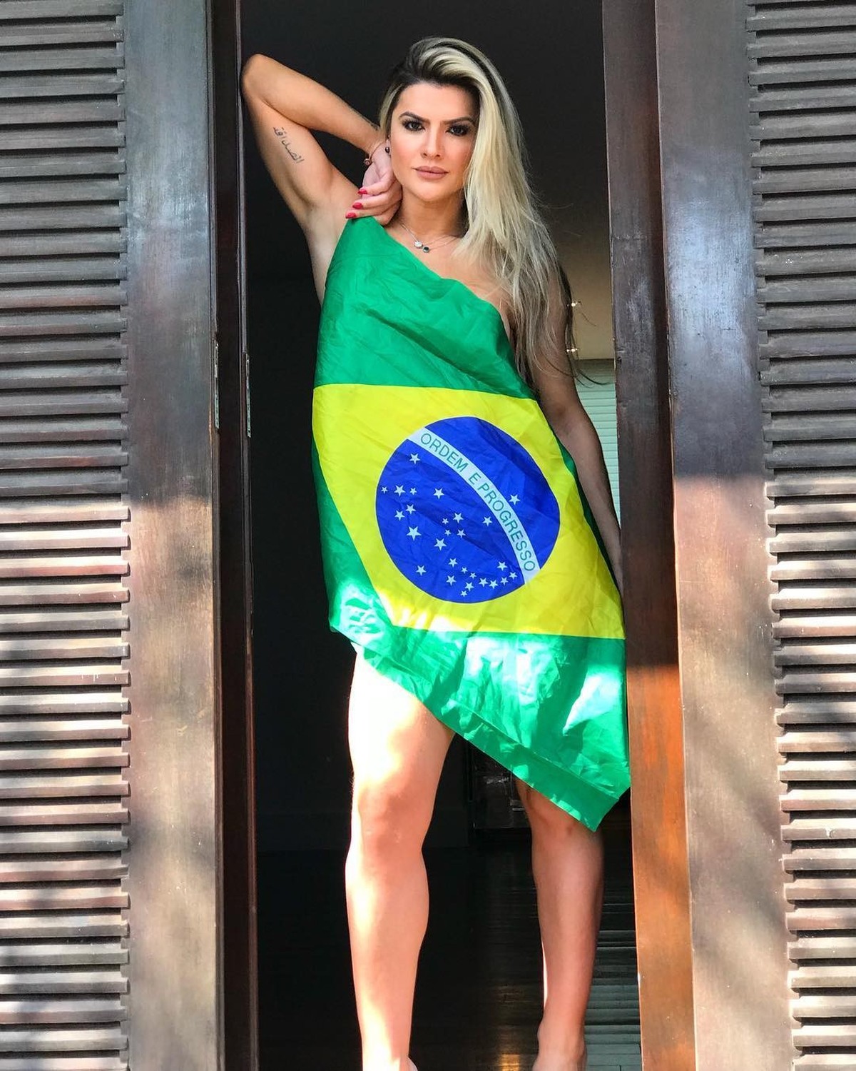 Em dia de jogo, Mirella Santos cobre o corpo só com a bandeira do