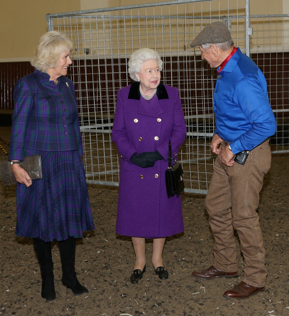 Monty Roberts com Camilla e a falecida Rainha Elizabeth II nas Cavalariças Reais do Palácio de Buckingham, em Londres, em 2015 — Foto: Getty Images