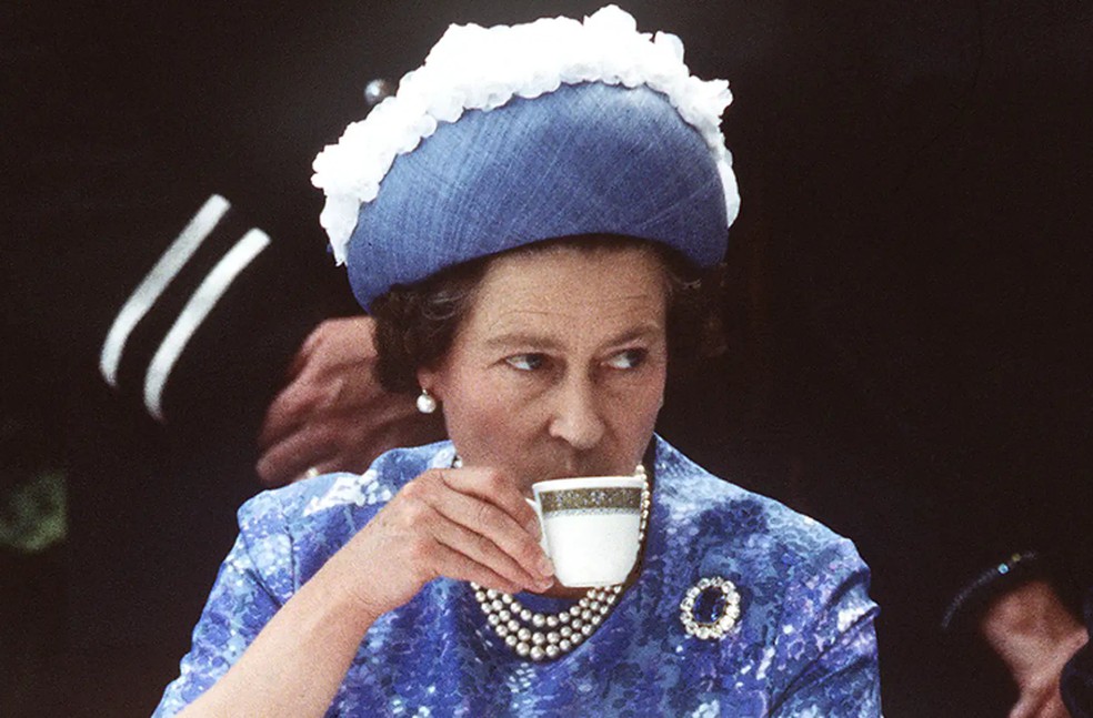 A rainha Elizabeth tomando uma xícara de chá durante uma visita real à Irlanda do Norte em 1977 — Foto: Getty Images