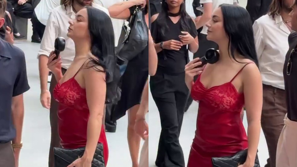 Charli XCX tentou driblar o calor recorde de Paris com um ventilador portátil durante o desfile masculino de verão 2027 do Saint Laurent, nesta semana — Foto: Reprodução
