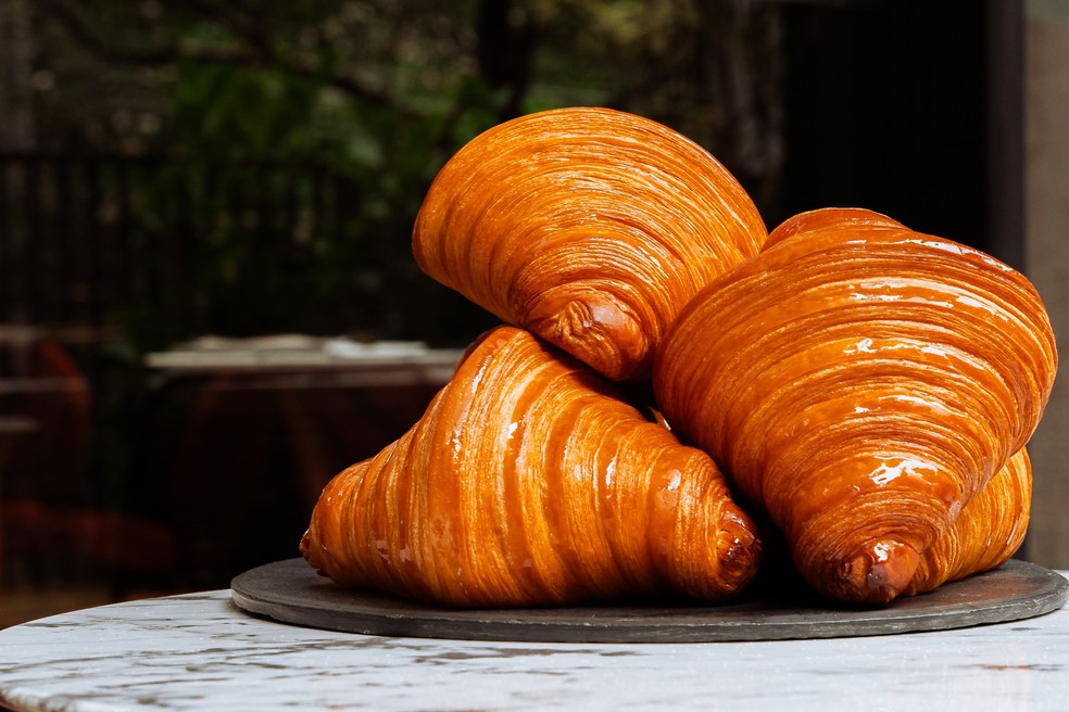 Os croissants são feitos com cerca de 20% a 30% de manteiga em relação ao peso total da massa; na produção da viennoiserie, a manteiga é laminada e dobrada em meio à massa para formar as famosas camadas — Foto: Gustavo Ferreira/Divulgação
