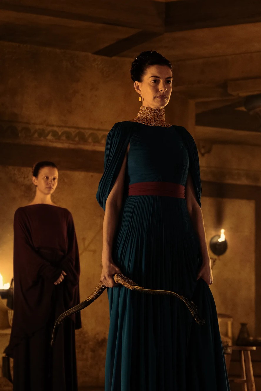 Mia Goth como Melantho e Anne Hathaway como Penelope