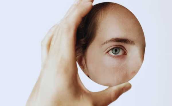 Procedimento para mudar a cor dos olhos.  uma mulher olhando o próprio olho em um espelho